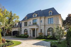 a large house with lots of windows in the front yard and landscaping on both sides