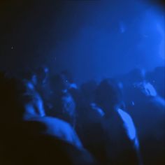 a group of people standing in front of a blue light