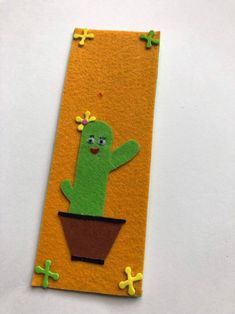 a felt bookmark with a green cactus in a flower pot on an orange background