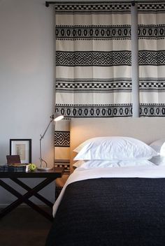 a bed with two black and white wall hangings over it's headboard