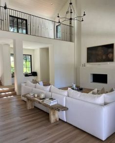 a living room filled with white couches and a fire place next to a fireplace