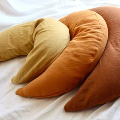 three pillows are laying on top of each other in the shape of an oval pillow