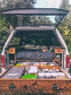 the back end of a truck with an open trunk filled with food and drinks in it