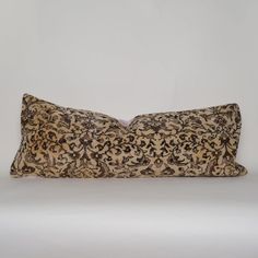 an animal print pillow is sitting on a white surface with a black and brown pattern