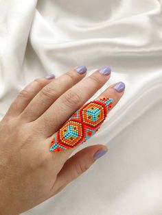 a woman's hand with colorful beaded rings on her fingers and manicured nails