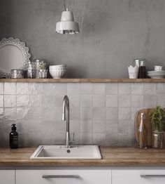 a white kitchen sink sitting next to a wooden counter top