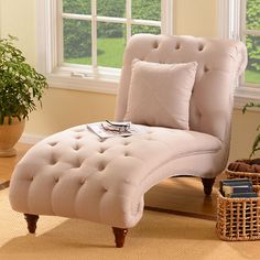 a chaise lounge chair sitting in front of a window next to a potted plant