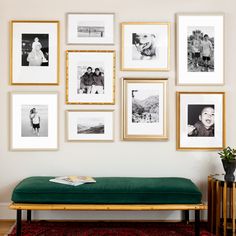 a green bench sitting in front of a wall with pictures on it's side