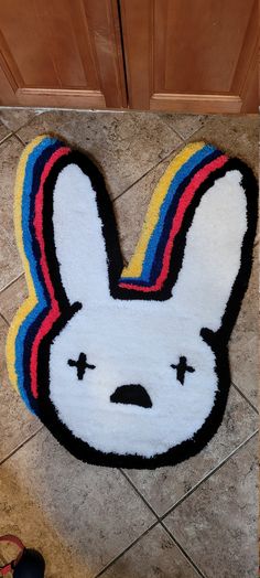 a rug that looks like a bunny with a rainbow stripe around its head on the floor