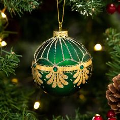 a green and gold ornament hanging from a christmas tree