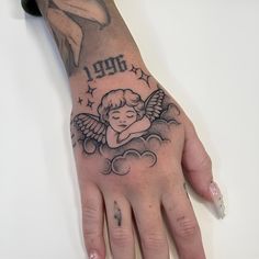 a woman's hand with an angel tattoo on it