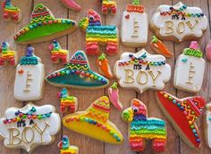 decorated cookies are laid out on a wooden table with the words it's a boy