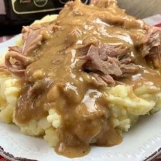 a white plate topped with mashed potatoes covered in gravy next to an instant pot roast