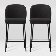 pair of black upholstered bar stools with arms and backrests, viewed from the front