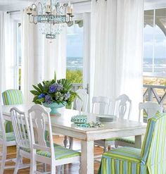 a dining room table with green and white chairs