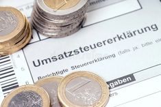 some euro coins sitting on top of a paper with the word unstazederkrarung written in german