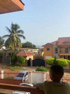 a young boy is looking out the window at his house and car in front of him