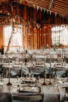 the tables are set for an event with white linens and silverware on them