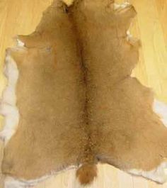 a brown and white cowhide rug on a wooden floor