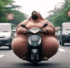 a person riding on the back of a motorcycle down a street with cars behind it