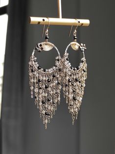 This tassel earring features a combination of black spinel and silver plated Labradorite, with a oxidized silver hoops in the middle and finely crafted textures. The other parts of the metal are matched with 14k gold-filled, and they shine together very brightly and have a gentle feeling, without putting any burden on the earlobes. ●black spinel ●silver plated labradorite ●oxidized silver ●14k gold filled ●mother of pearl flower ● total length: 3.58 inches ● weight：4.8g Welcome to visit my Jewelry store: https://www.etsy.com/shop/Ukuly 🌸The delivery time to Most regions of North America, Australia and Europe is usually about 10-15 days. Buyers from Brazil, South Korea, and Indonesia, please provide me with your tax number through messages or notes for smooth shipment. Thank you. 🌸Please Bohemian Dangle Earrings For Evening, Elegant Black Fringe Chandelier Earrings, Elegant Handmade Long Drop Tassel Earrings, Elegant Long Drop Handmade Tassel Earrings, Handmade Evening Chandelier Dangle Earrings, Unique Dangle Tassel Jewelry, Bohemian Tassel Earrings For Evening, Bohemian Fringe Earrings For Evening, Bohemian Dangle Chandelier Earrings For Evening