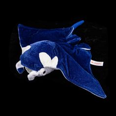 a blue stuffed animal laying on top of a black surface