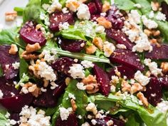 a salad with beets, feta cheese and walnuts on top is shown