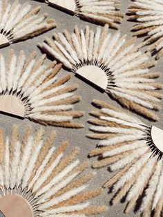 several white and brown feathers are arranged on a gray surface, with wooden spoons in the foreground