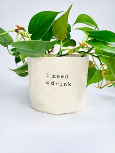 a plant pot with the words i need a drink printed on it