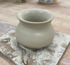 a white vase sitting on top of a stone slab