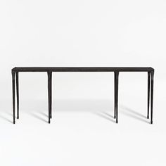 a black table sitting on top of a white floor next to a wooden frame and legs