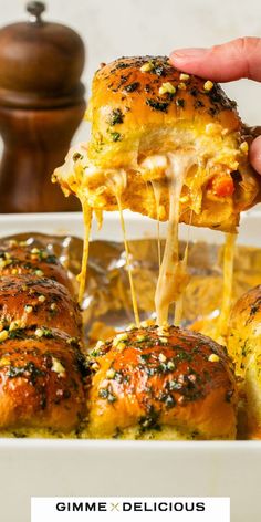 someone is lifting some food out of the casserole dish with cheese on top