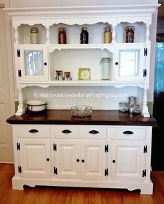 an old china cabinet is painted white with black trim