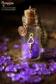 a glass jar filled with purple crystals and a key