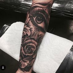 a woman's arm with an eye and roses on it