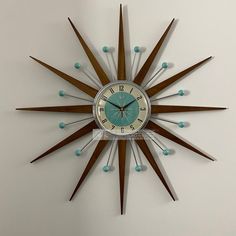 a clock that is on the wall with wood sticks and beads around it's face