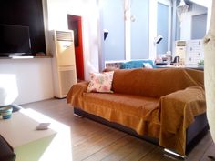 a living room filled with furniture and a flat screen tv on top of a wooden floor