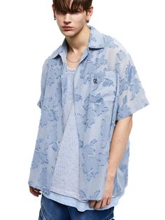 This is a casual and unique shirt with short sleeves that is made out of high quality polyester 100% fabric. With design detail of light fabric with flower pattern and oversized silhouette, it gives a comfortable and trendy mood.- RSCC Logo metal emblem on the chest- Light fabric with flower pattern- Rough fringe detail- Logo engraved buttons detail Light Blue Short Sleeve Top With Floral Embroidery, Relaxed Fit Short Sleeve Shirt With Floral Embroidery, Light Blue Short Sleeve Shirt For Spring, Oversized Floral Print Shirt For Summer, Light Blue Oversized Short Sleeve Shirt, Blue Short Sleeve Shirt With Camp Collar For Spring, Blue Floral Print Casual Short Sleeve Shirt, Blue Relaxed Fit Short Sleeve Shirt For Spring, Light Blue Floral Print Shirt For Summer