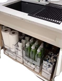 a sink that has some bottles and toilet paper in it next to a counter top