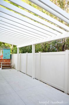 a white fence with a bench in the background