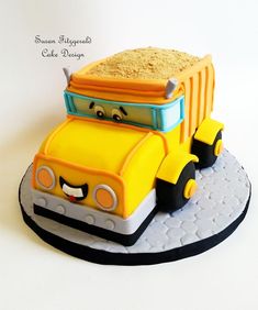 a cake made to look like a truck with sand in the back and eyes on top