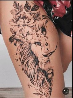 a woman's thigh with flowers and a lion tattoo on her leg, which is decorated