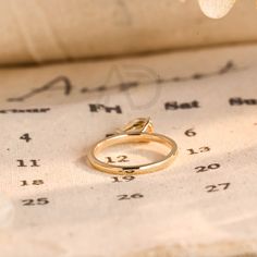 a gold ring sitting on top of an old sheet of paper with numbers in the background