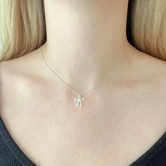 This sweet necklace features a small bow charm that boasts a beautiful bright and shiny polish.  The bow is made of sterling silver and it measures 13mm wide and about 11mm long (not including the loop). The bow slides freely along sterling silver cable chain for a simple minimalist design that can easily transition from casual to dressy. The necklace would be ideal for every day wear and would add a nice whimsical accent to an outfit. Ribbons and bows are popular right now so this accessory is White Necklace With Butterfly Knot For Gift, Feminine Ribbon Necklace As Gift, Feminine Ribbon Necklace For Gift, Feminine Silver Jewelry With Bow, Dainty Ribbon Jewelry For Gifts, Silver Bow Jewelry As A Gift, Silver Bow Jewelry For Gift, Delicate Silver Jewelry With Bow Detail, Delicate Silver Jewelry With Bow