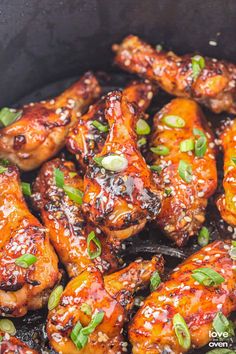 chicken wings with sesame seeds and seasoning in a skillet, ready to be eaten