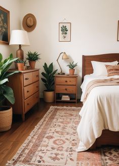 a bed room with a neatly made bed and two planters on the side tables