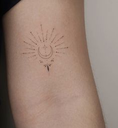 a small sun and moon tattoo on the back of a woman's left thigh