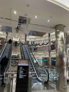 an escalator in a shopping mall with people walking up and down the stairs