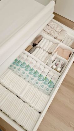 an open drawer filled with lots of personal care items on top of a wooden floor