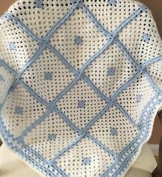 a crocheted blue and white dishcloth on a wooden stand